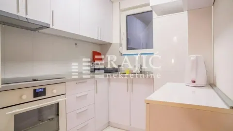 Small white kitchen with built-in cabinetry and a window. - image 4