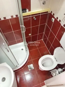 Kupatilo sa tuš kabinom i crvenim zidnim pločicama. - image 10
