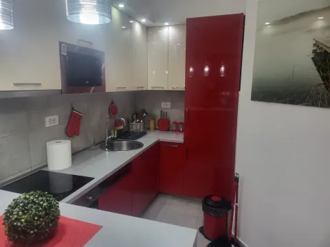 Modern kitchen featuring a combination of red and white cabinets with built-in appliances. - image 8