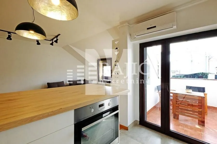 Modern kitchen with built-in oven and access to the terrace.