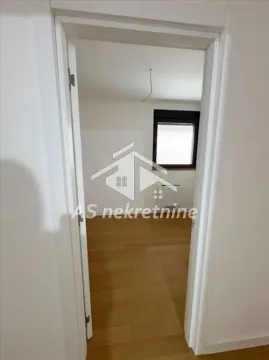 Pogled kroz vrata na praznu prostoriju sa parketom i prozorom. - image 10