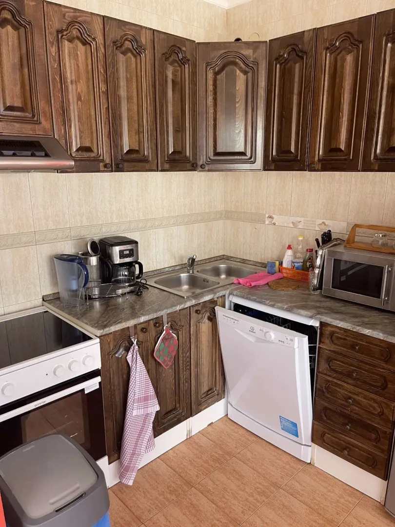 Kitchen with wooden cabinets, a stove, and a dishwasher.