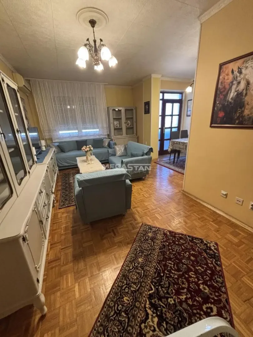 Spacious living room with a seating set and parquet flooring.