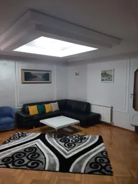 Living room with a sectional sofa, coffee table, and rug. - image 10