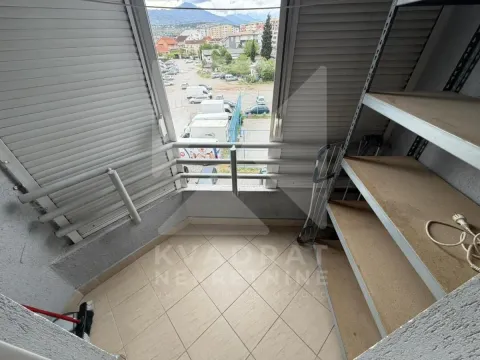 Enclosed balcony with shelving units and a view of the parking area and neighborhood. - image 12