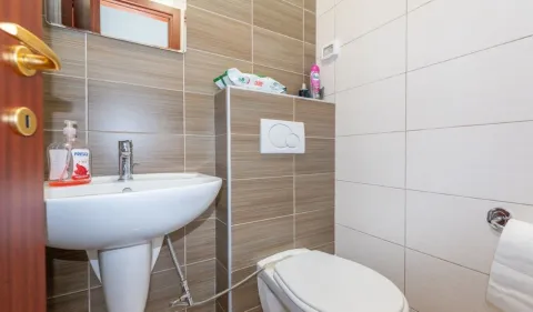 Manje kupatilo sa umivaonikom, WC šoljom i zidnim pločicama. - image 10