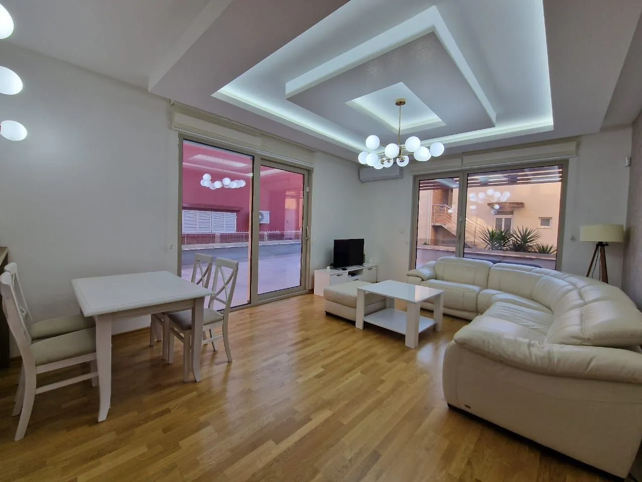 Living room with a sofa set, dining table and access to the terrace.