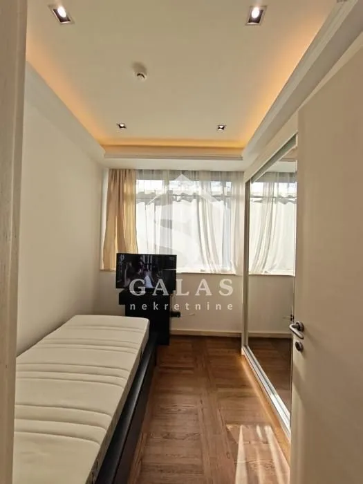 Smaller bedroom with a bed, wardrobe, and window.