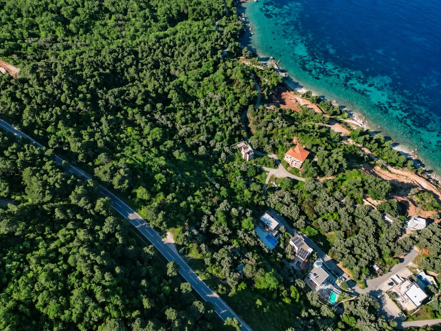 Pogled iz vazduha na obalu, šumu i put.