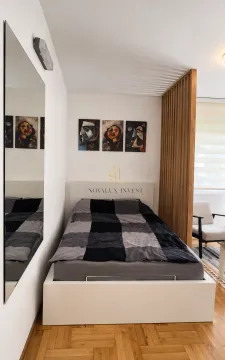 Spavaća soba sa bračnim krevetom, velikim ogledalom i drvenim pregradnim paravanom. - image 3