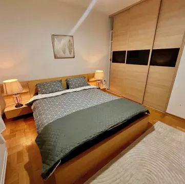 Furnished bedroom with a double bed, bedside lamps, and a fitted wardrobe. - image 7