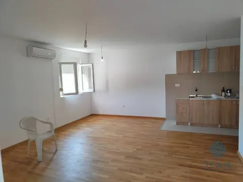 Dnevni boravak sa kuhinjom u uglu, drvenim podom i klima uređajem. - image 3