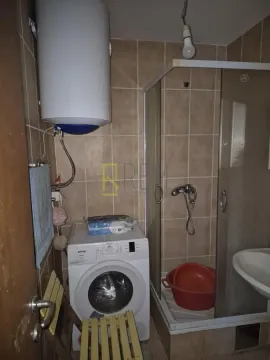 Manje opremljeno kupatilo sa tuš kabinom i veš mašinom. - image 3