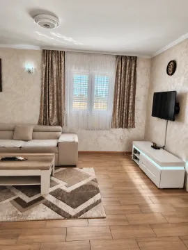 Living room with a sofa, coffee table, TV, and a window with curtains. - image 6