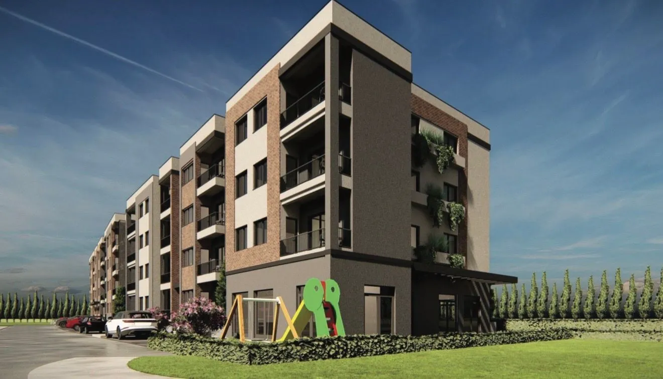 Spoljašnji izgled moderne stambene zgrade sa uređenim dvorištem i igralištem.