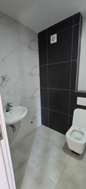 Manje kupatilo sa umivaonikom i toalet šoljom.