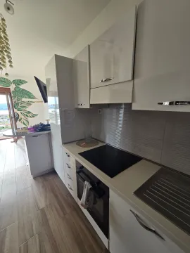 Moderna bijela kuhinja sa ugradnom pločom i šankom u nastavku. - image 10