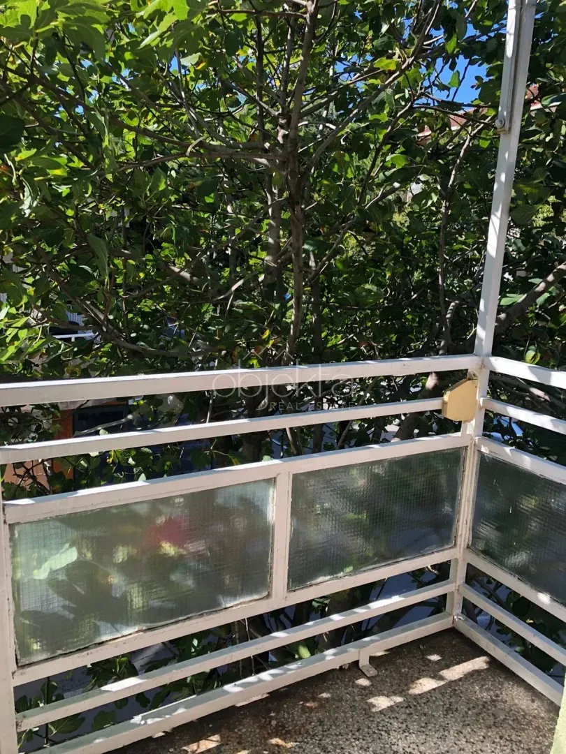 Balcony with metal railing and tree canopy view.