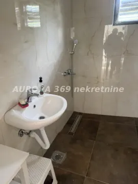 Manje kupatilo sa umivaonikom i tuš kabinom obloženo keramičkim pločicama. - image 10