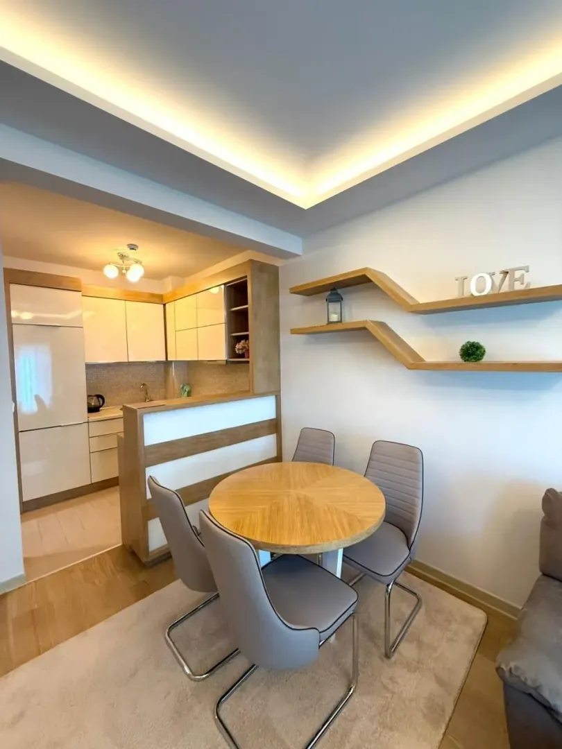 Dining area with a round table and chairs, overlooking the open-plan kitchen.