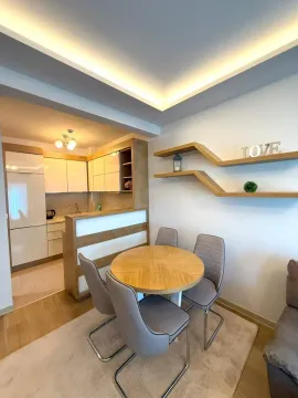 Dining area with a round table and chairs, overlooking the open-plan kitchen. - image 4