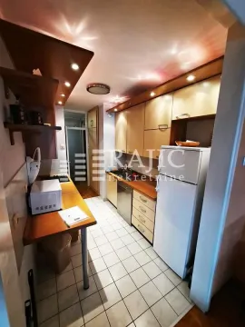 Compact equipped kitchen with a white refrigerator and wooden cabinets. - image 5