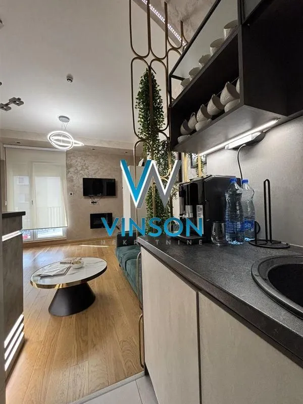 View from the kitchen towards the living room in a modern furnished apartment.