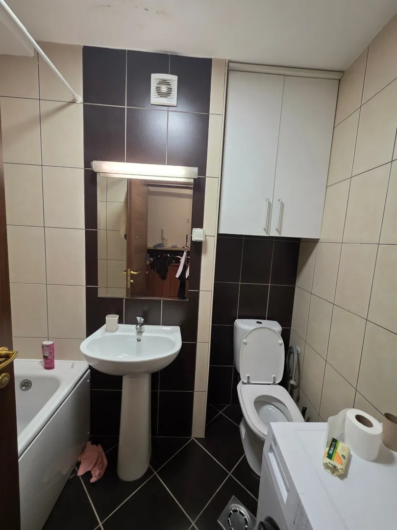 Small bathroom with a washbasin, toilet, and bathtub.