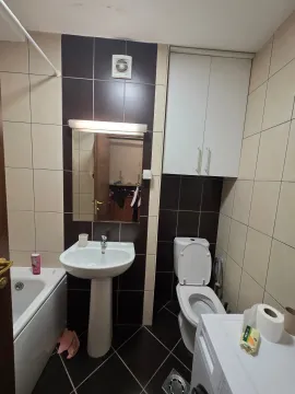 Small bathroom with a washbasin, toilet, and bathtub. - image 14