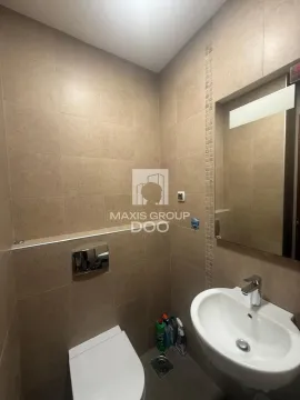 Small bathroom tiled in beige with a washbasin and toilet. - image 17