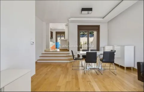 Spacious living room with a dining area and wooden flooring. - image 2