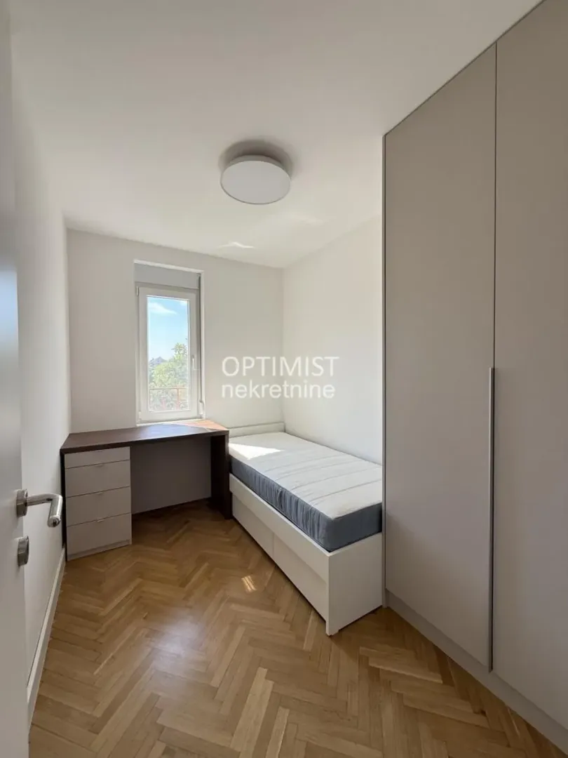 Smaller bedroom furnished with a bed, desk, and built-in wardrobe.