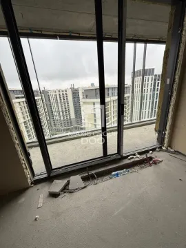 View through a large window from an unfinished room towards neighboring buildings. - image 9