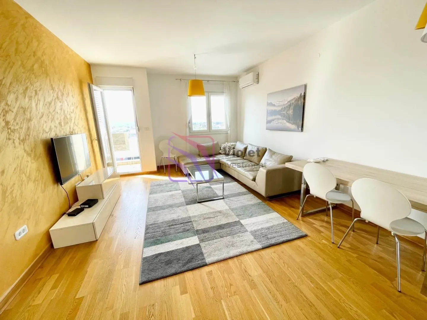 Living room with a sofa, TV, and dining table.