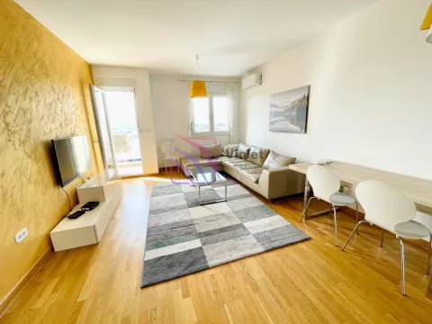 Living room with a sofa, TV, and dining table. - image 2