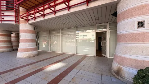 View of the commercial space entrance featuring a glass storefront and decorative pillars. - image 4