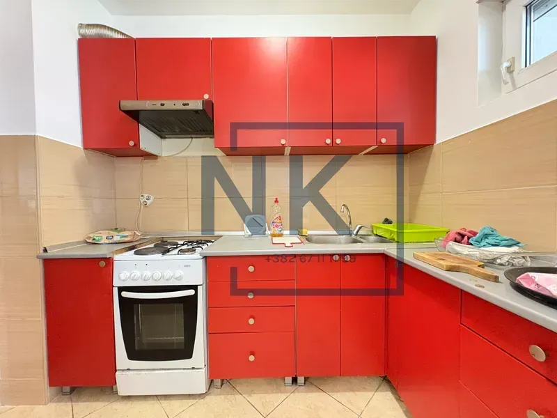 Kitchen with red cabinets and a white stove.