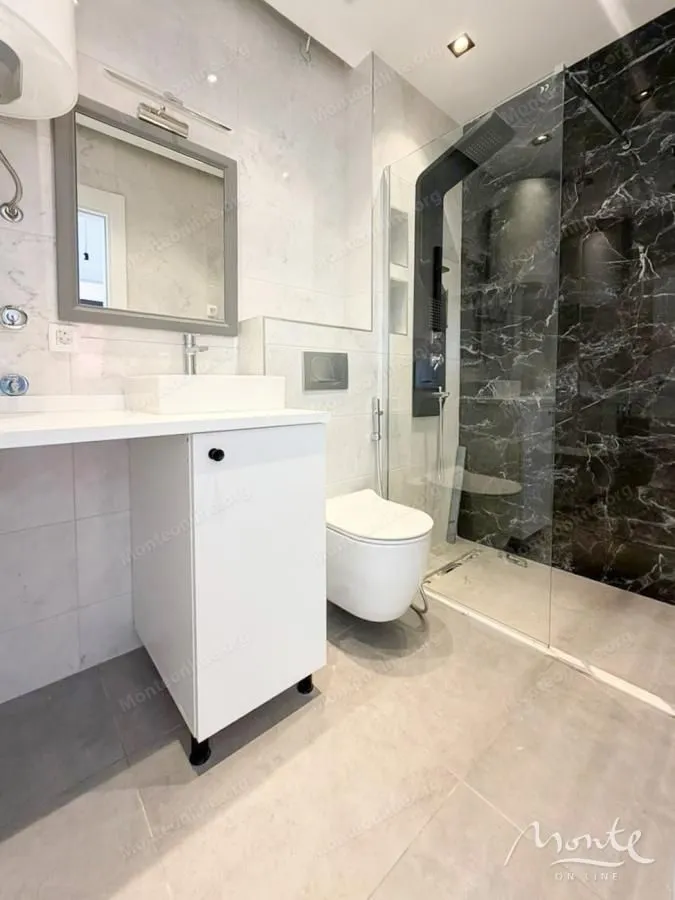 Moderne kupatilo sa tuš kabinom, umivaonikom i wc šoljom.
