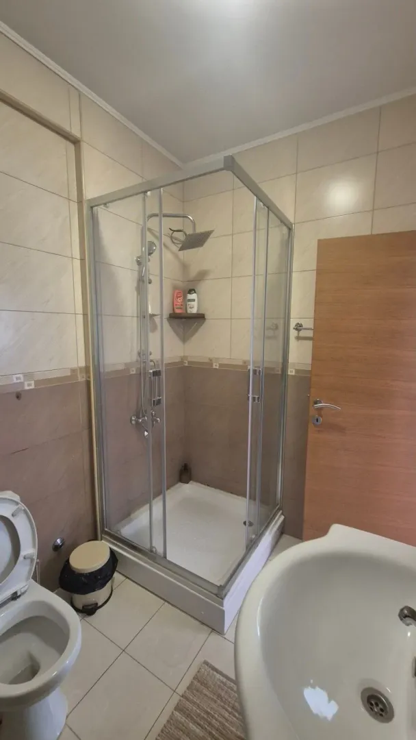 Small bathroom with a shower cabin, washbasin, and toilet.