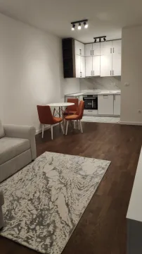 Moderan dnevni boravak sa trpezarijom i ugradnom kuhinjom u pozadini. - image 3