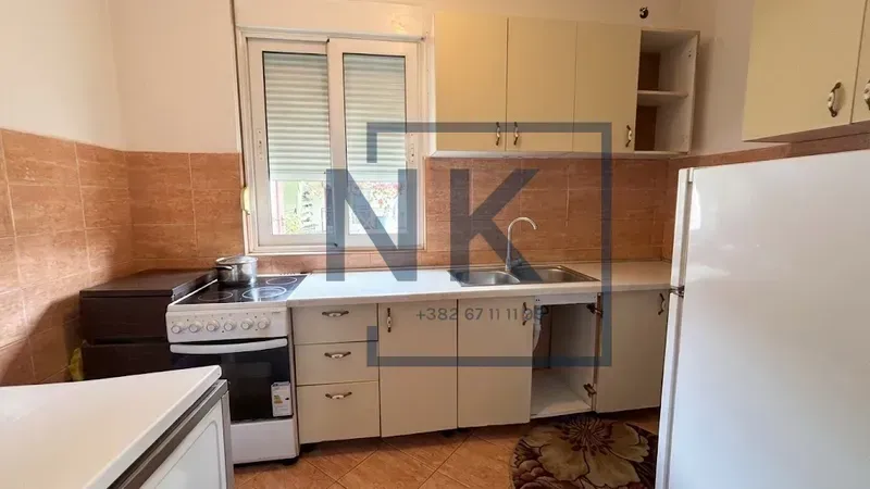 Small kitchen with white cabinets, stove, and refrigerator.