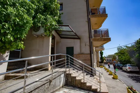 Exterior view of a residential building with an entrance and stairs. - image 11