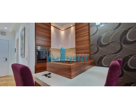Kitchen with built-in cabinetry and a dining table with purple chairs. - image 3