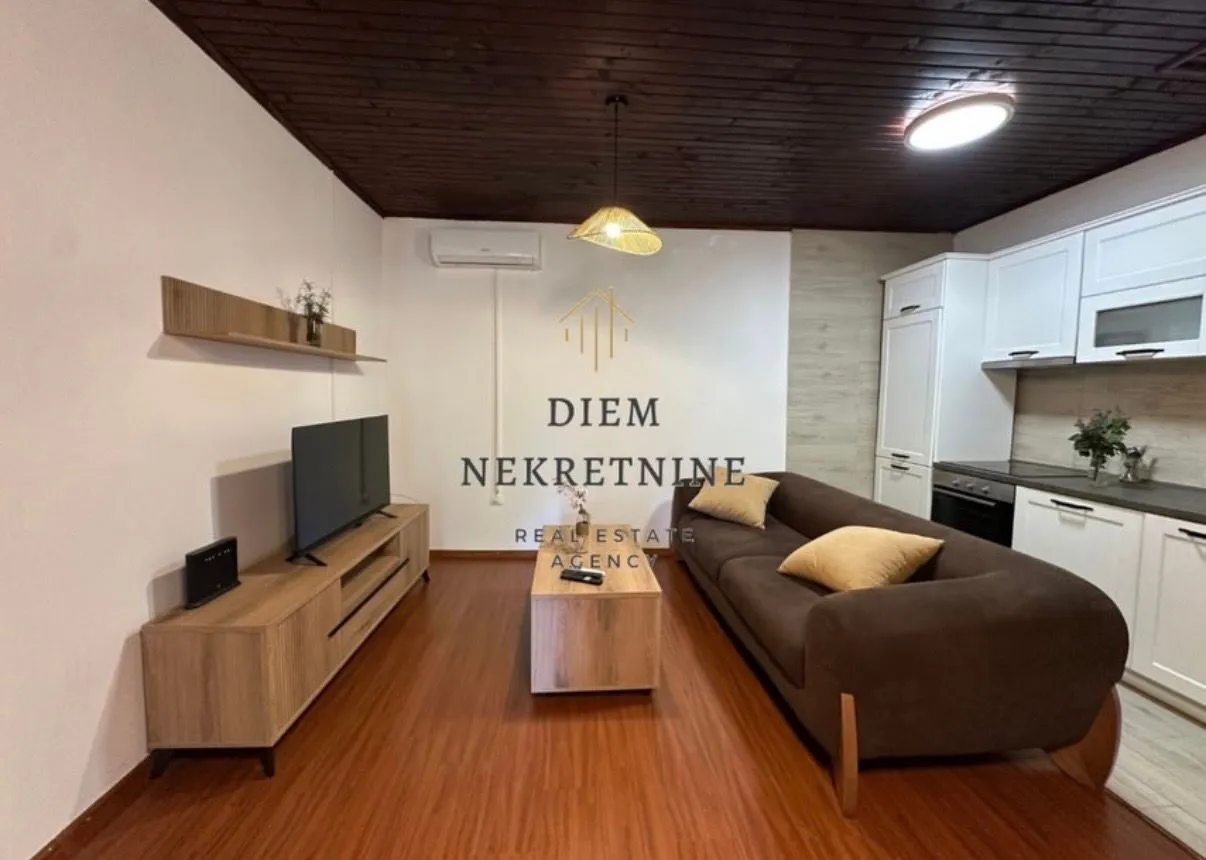 Living room with sofa and dining area in an open space layout.