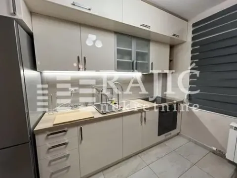 Modern kitchen with beige cabinets and built-in appliances. - image 5