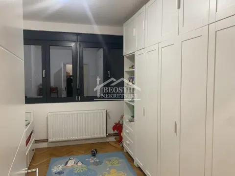 Children's bedroom with white wardrobes, a bed, and a window. - image 4