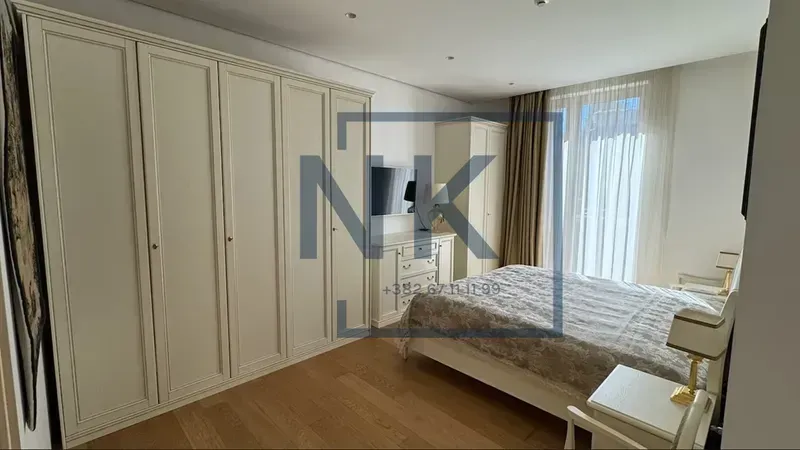 Spacious bedroom with a large double bed and a fitted wardrobe.