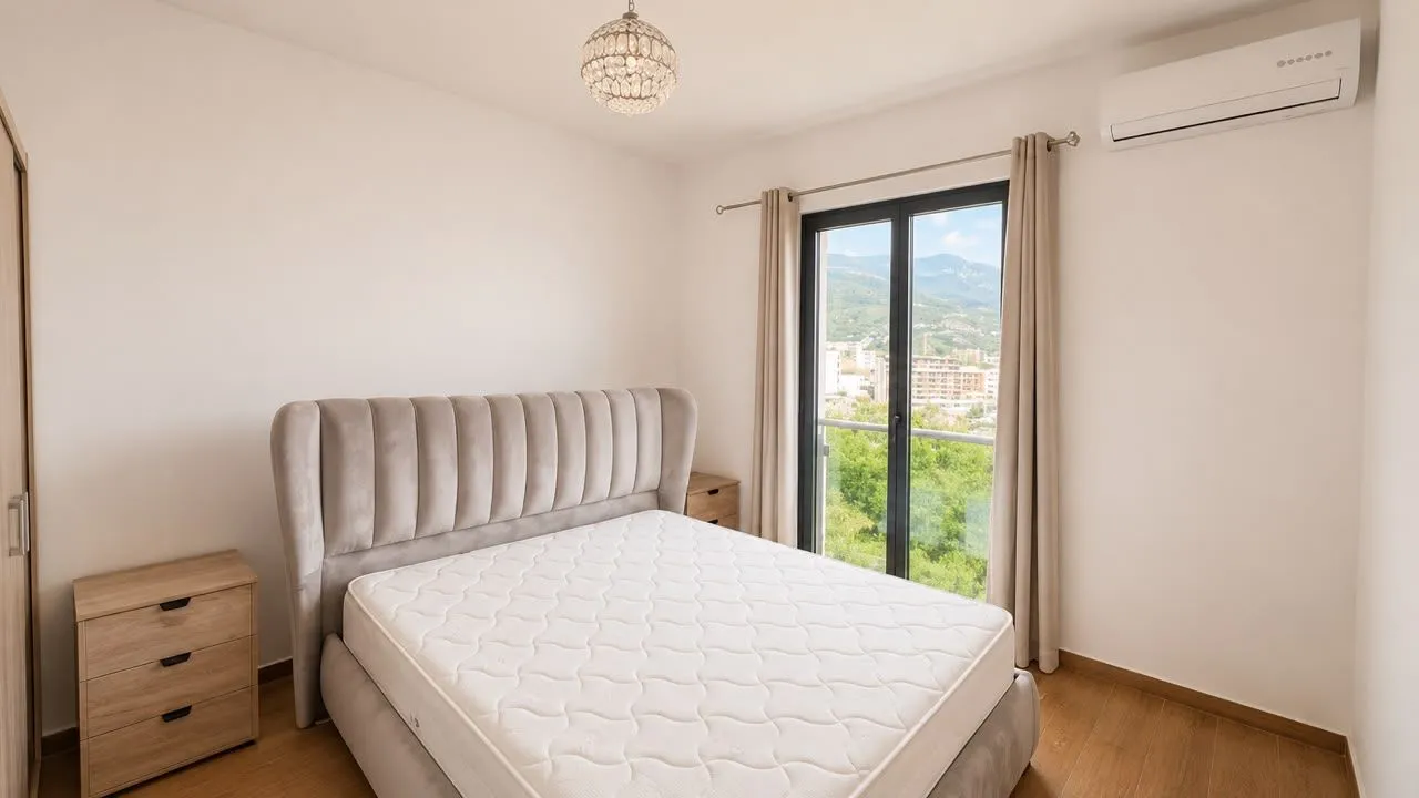 Svjetla spavaća soba sa bračnim krevetom, noćnim stočićima i izlazom na balkon.