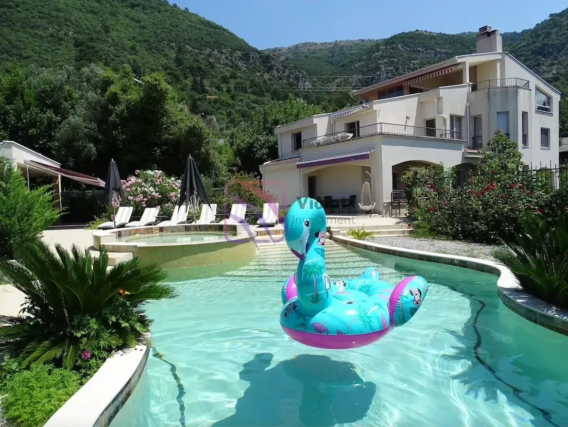 Bazen u dvorištu porodične kuće sa ležaljkama i pogledom na planine.