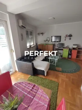 Living room with a sofa set, a desk, and a dining table in the foreground. - image 2